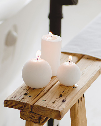Image: 3 pink candles on a wooden side table