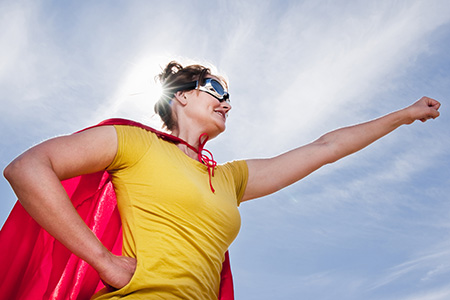 An eco warrior: A woman wearing a red cape and super hero mask